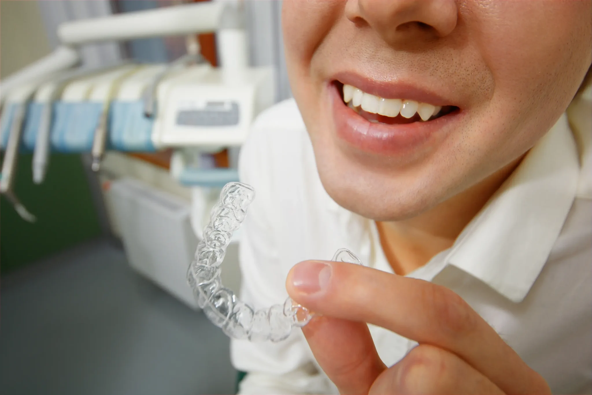 hombre adulto sonriendo con ortodoncia en la mano